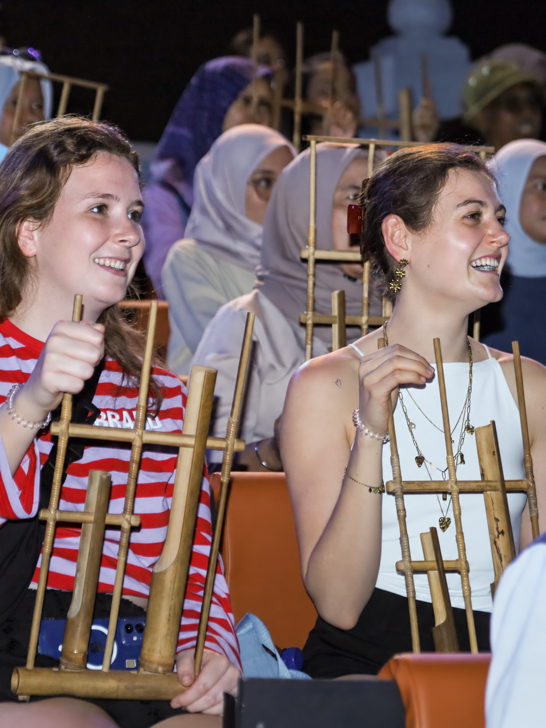 Guests playing bamboo angklung instruments together