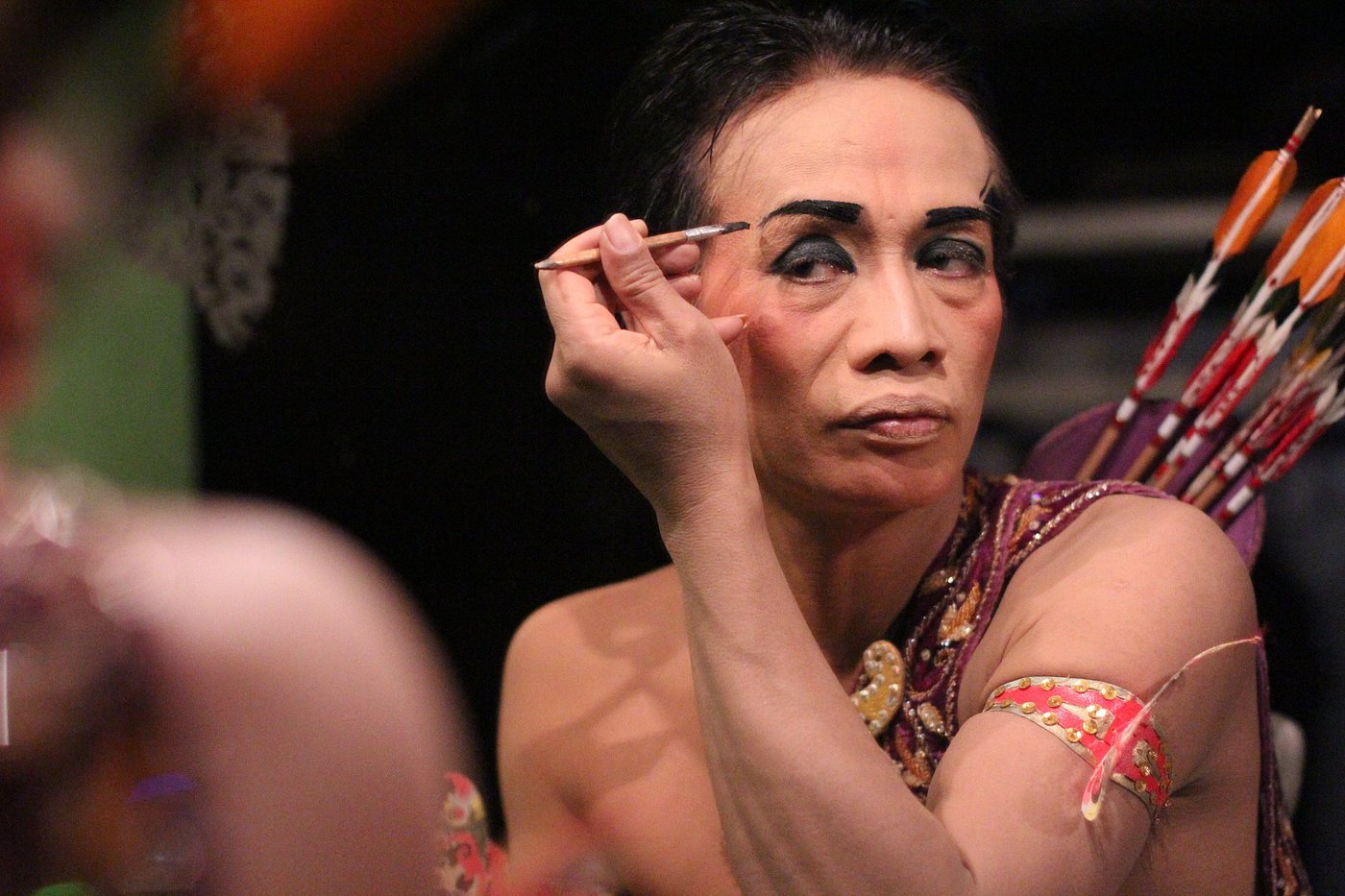 A performer applying makeup before going on stage